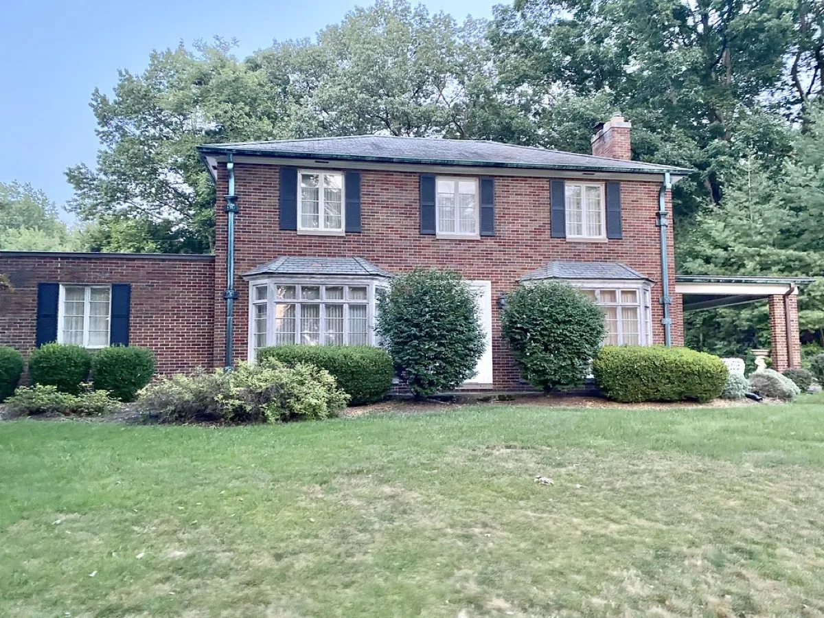 Period brick colonial home with half-round aluminum gutters on the eaves, Charlotte NC style