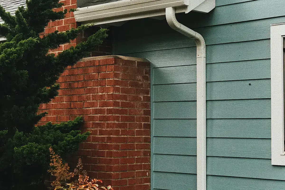 Blue clapboard house with seamless gutters and downspout in Charlotte NC